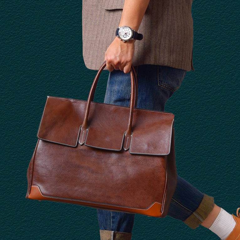 Brown top-grain leather large business tote bag held by a person wearing a watch, stylish and functional for professionals.