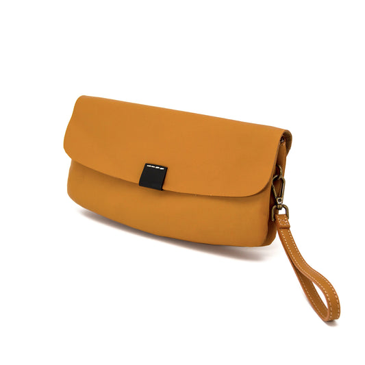Tan full-grain leather clutch bag with a wristlet strap and black accent tab, shown against a white background.