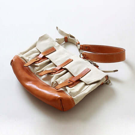 Canvas Leather Messenger Bag featuring leather trim and buckle closures, a stylish vintage flap design for crossbody use.