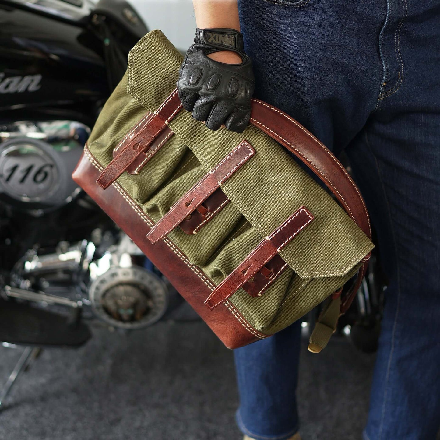 Canvas Leather Messenger Bag being carried by a person with gloves, showcasing a vintage design and multiple pockets.