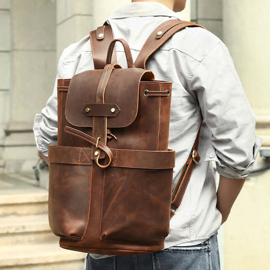 Men's Full Grain Leather Backpack 16.5" Laptop Travel Bag in dark brown worn by a person outdoors.