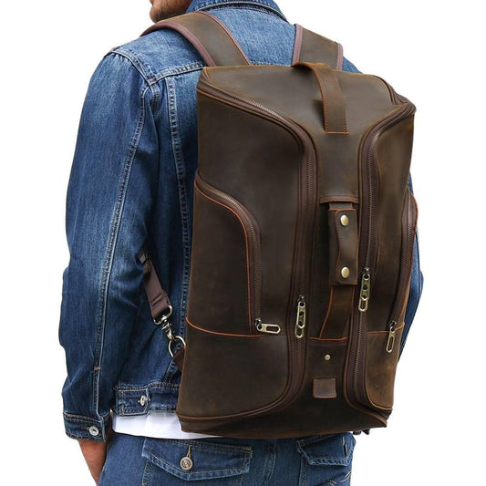 Leather Backpack 20.9in Convertible Duffel Bag Travel For Men worn on a person's back in a dark brown color.