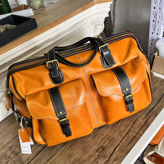 Handmade Leather Travel Bag With Wheels in orange color, featuring two front pockets, perfect for travel.