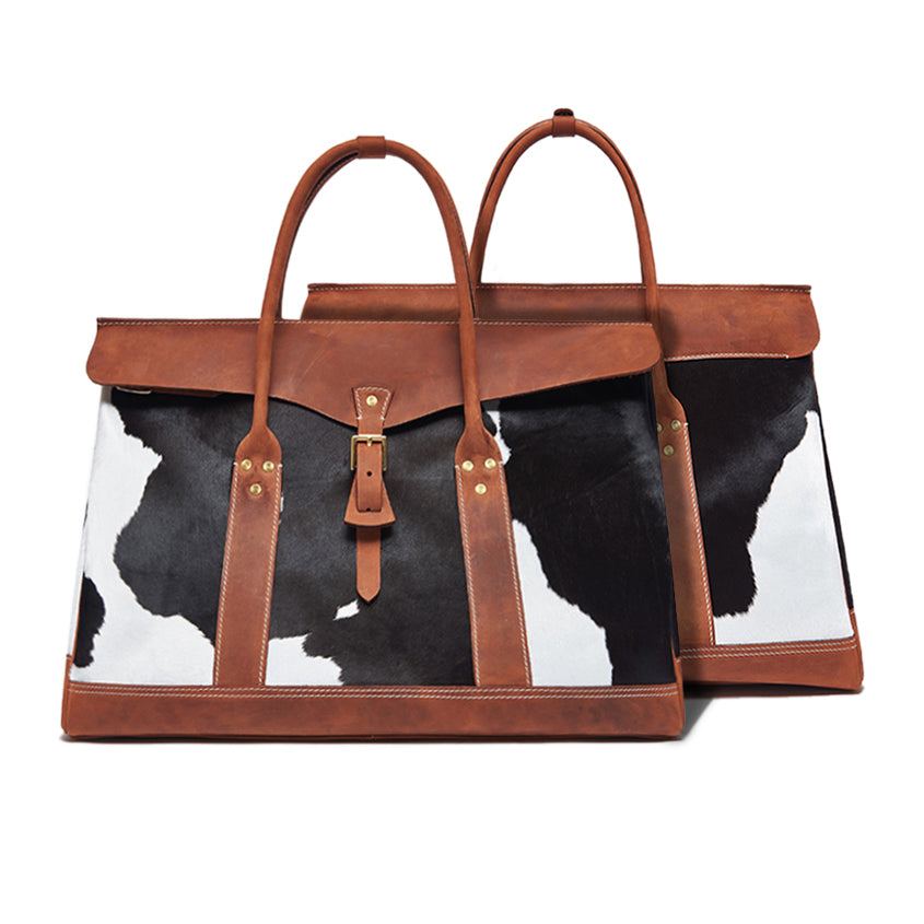 Tote bag with cow print and brown leather straps on a white background