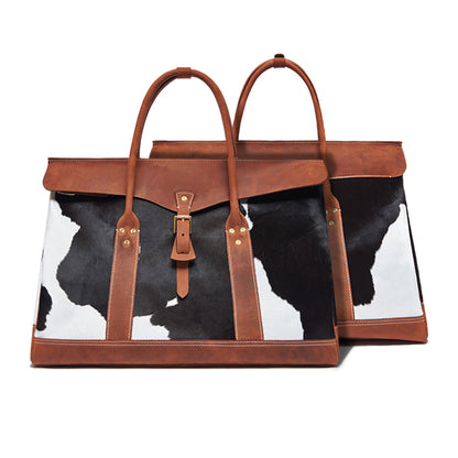 Tote bag with cow print and brown leather straps on a white background