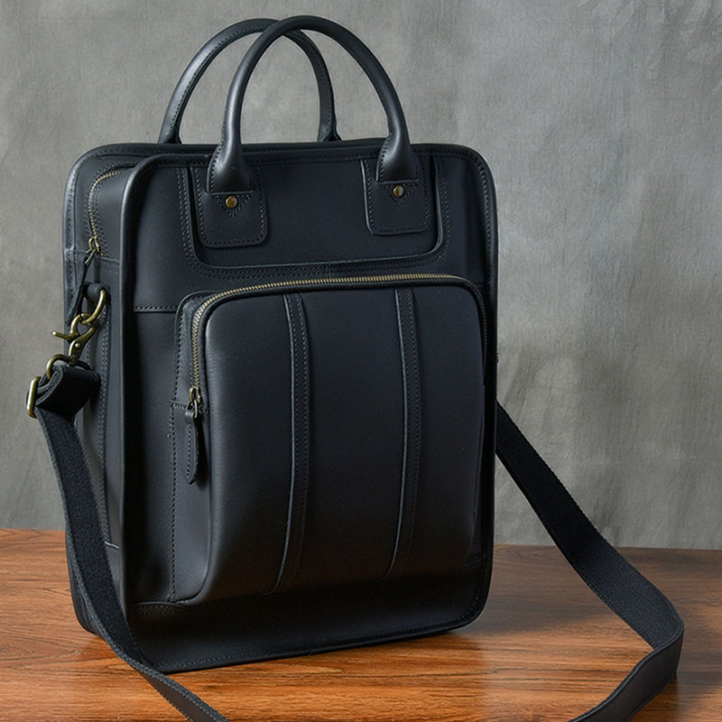 Stylish black leather laptop bag with top handles and adjustable shoulder strap, perfect for men.