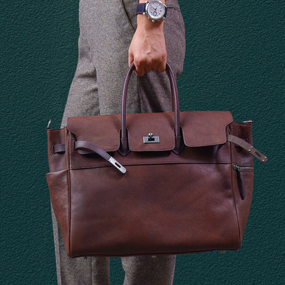 Men's brown leather work bag held by a person, featuring sturdy handles and a sleek design, perfect for business use.