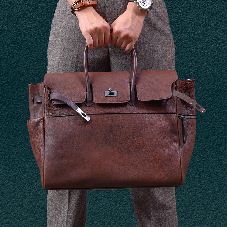 Mens brown leather work bag held by a person, featuring dual handles and a sleek design, perfect for business and daily use.