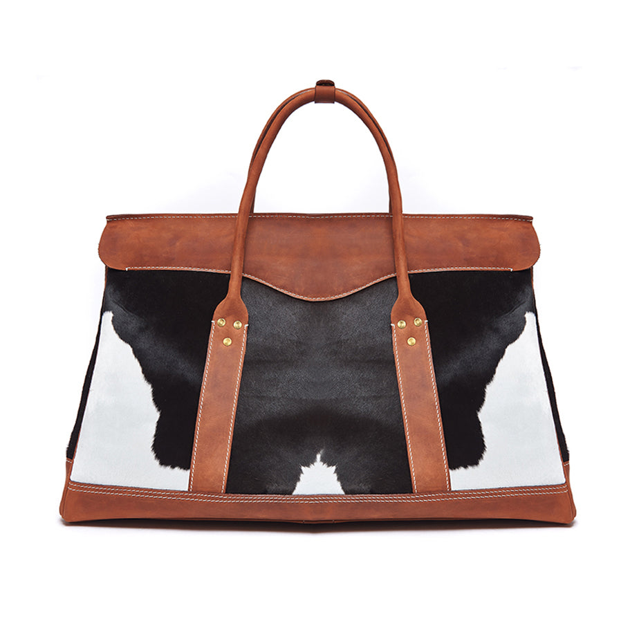 Bag with cow print and brown leather straps on a white background
