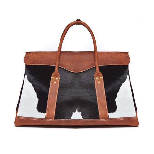 Bag with cow print and brown leather straps on a white background