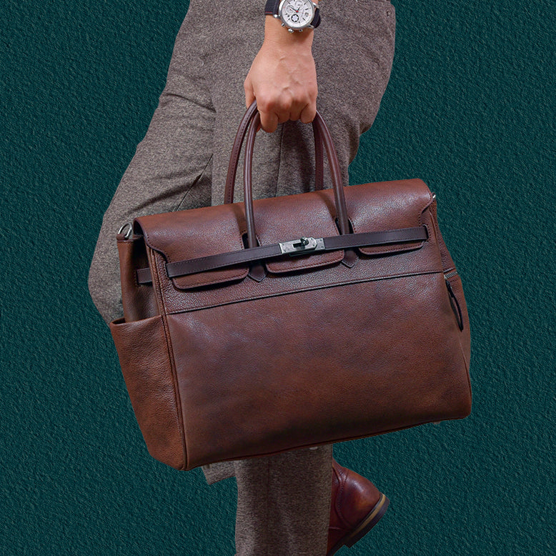 Mens leather work bag held by a person, stylish business tote with brown finish.
