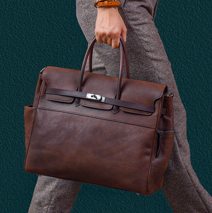 Man carrying a stylish brown leather tote work bag, featuring two handles and a sleek design.