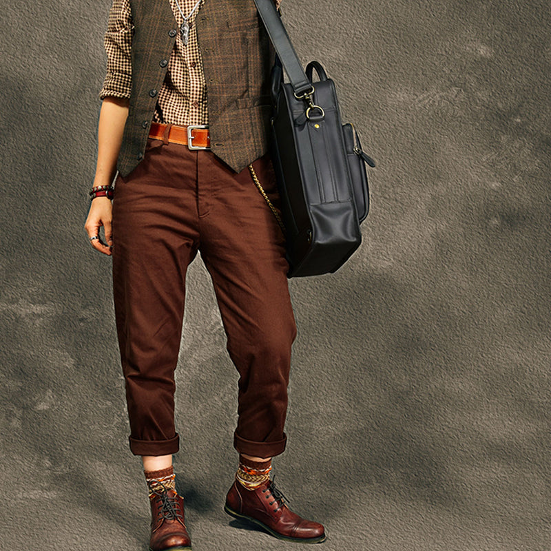 Man in stylish outfit with a leather laptop bag, showcasing a modern and professional look.