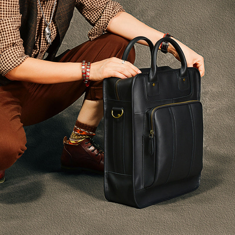 Stylish black leather laptop bag held by a person, perfect for men and designed for 15-inch laptops.