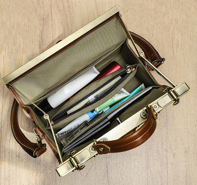 Interior view of a tan leather handbag showing organizational pockets and contents including cosmetics and a notebook.