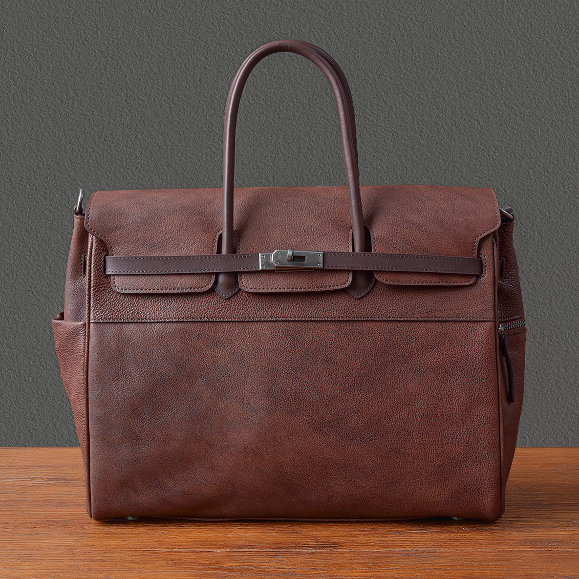 Mens leather business bag, 15-inch work tote in dark brown, featuring top handles and front buckle.