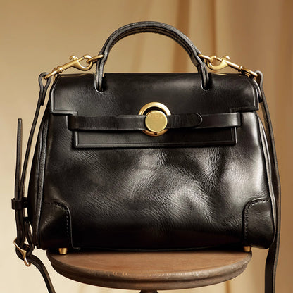 Classic Leather Bag in black with gold hardware on a wooden table.