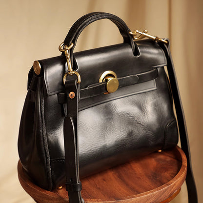 Classic Leather Bag in black on a wooden table, showcasing its stylish design and gold accents.