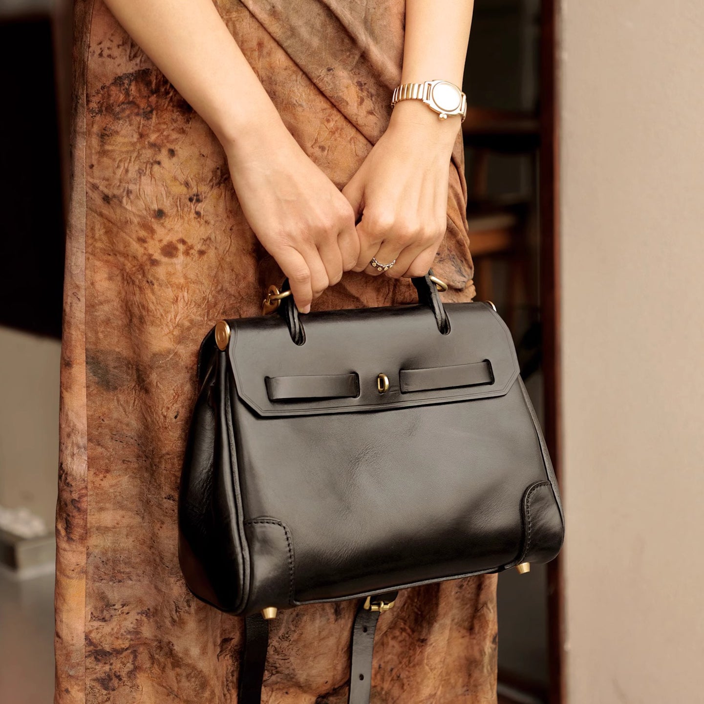 Classic Leather Bag held by a person wearing a stylish outfit, showcasing its elegant design and versatility.