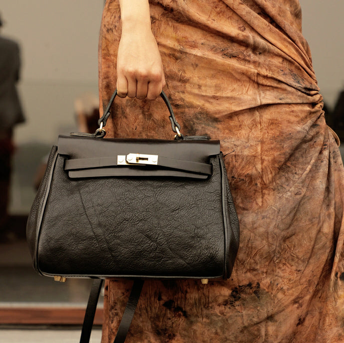 Italian Leather Tote Bag Women held by a person in a stylish outfit, showcasing its elegant design and craftsmanship.