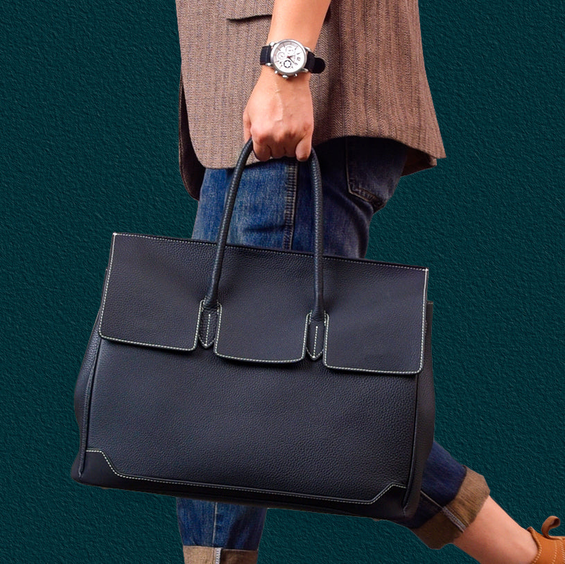 Large leather work bag being carried, showcasing a stylish design and spacious interior, ideal for professional use.