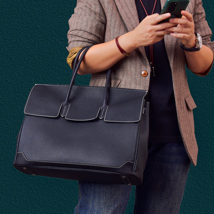 Large leather work bag being carried, ideal for professional use.