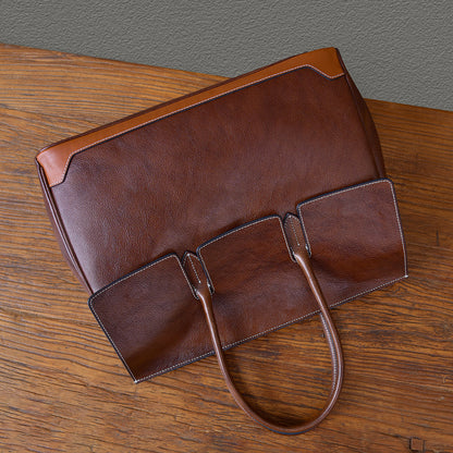 Top-grain leather large brown business tote bag with two open pockets and sturdy handles.