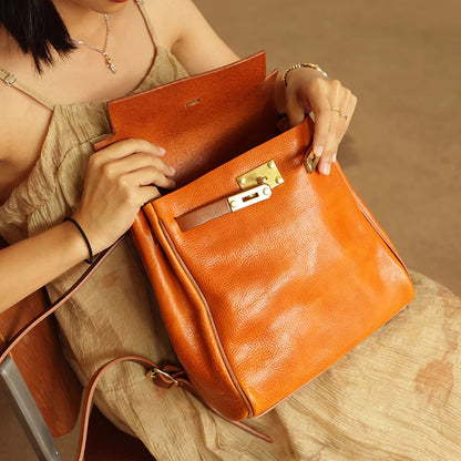 Stylish vegetable tanned leather backpack women small rucksack in orange being opened by a woman.