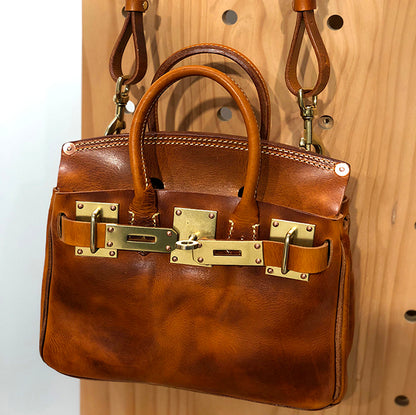 Leather Crossbody Bag Women in rich brown leather with gold hardware and dual handles, showcasing craftsmanship.