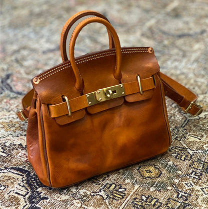 Handcrafted Italian Leather Crossbody Bag Women in rich brown with gold clasp detail on intricate background