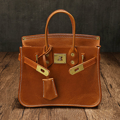 Classic Italian Leather Crossbody Bag Women in brown with gold accents on a wooden surface.
