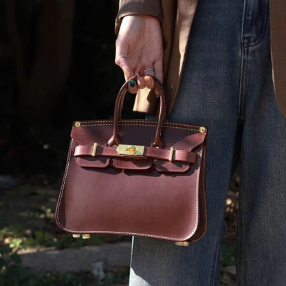Classic Italian Leather Crossbody Bag Women held by a person, showcasing a stylish dark brown design with gold accents.