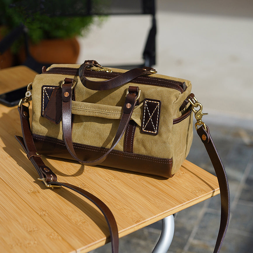 Handmade Canvas Leather Crossbody Bag Women on a wooden table showcasing its vintage style and craftsmanship.