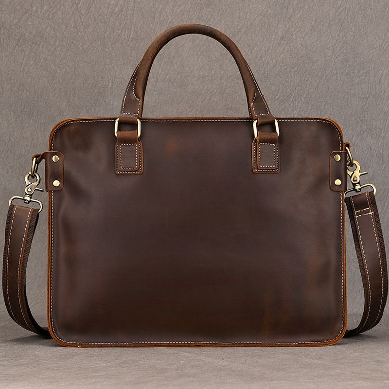 Heritage full-grain brown leather 15 inch laptop briefcase with top handles, brass hardware, and shoulder strap.