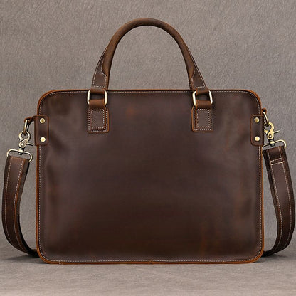Heritage full-grain brown leather 15 inch laptop briefcase with top handles, brass hardware, and shoulder strap.