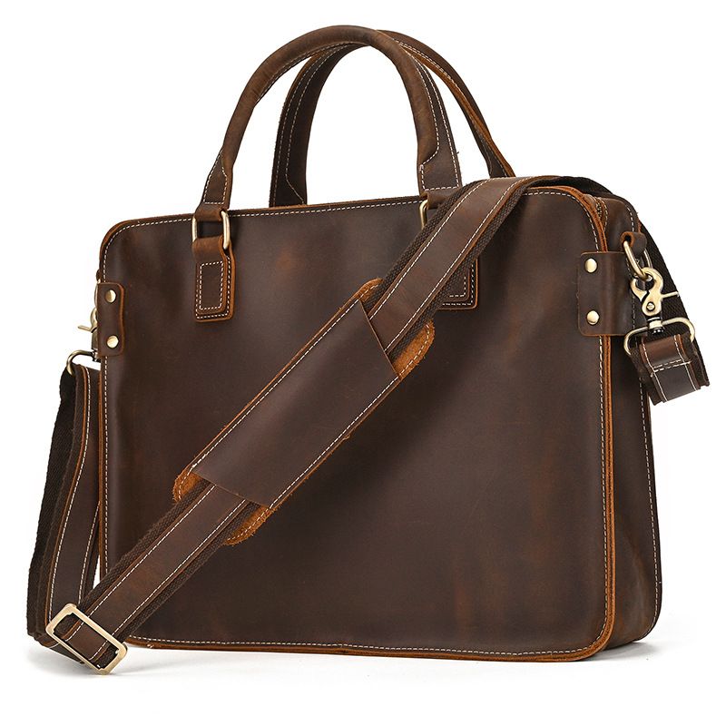 Full-grain leather 15" laptop briefcase with brass hardware, top handles, and adjustable padded shoulder strap.