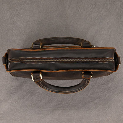 Top view of Heritage full-grain leather 15" laptop briefcase in dark brown with brass zipper and dual carry handles.