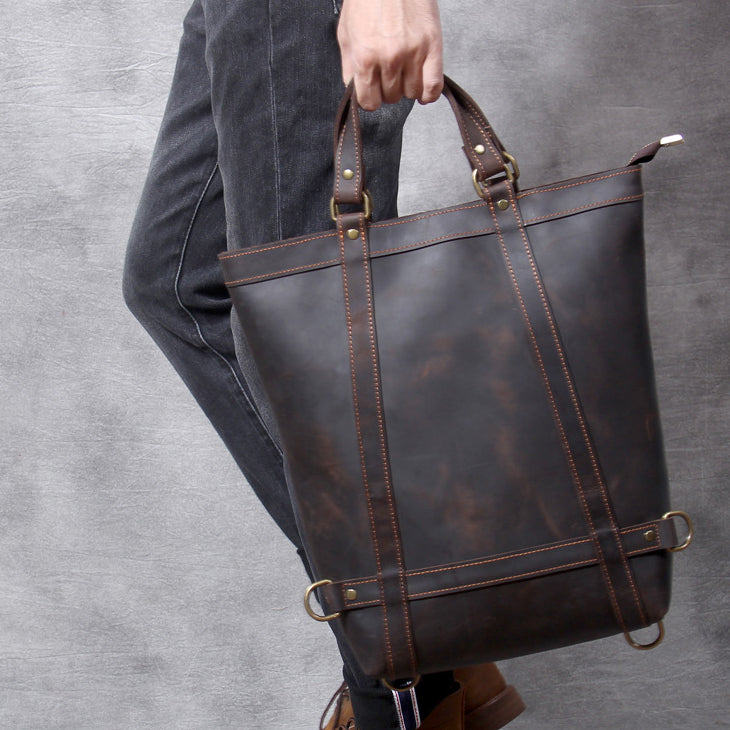 Full Grain Leather Backpack Tote 15in 3 Way Carry Laptop Bag Men held by a person, showcasing its dark brown color and design.