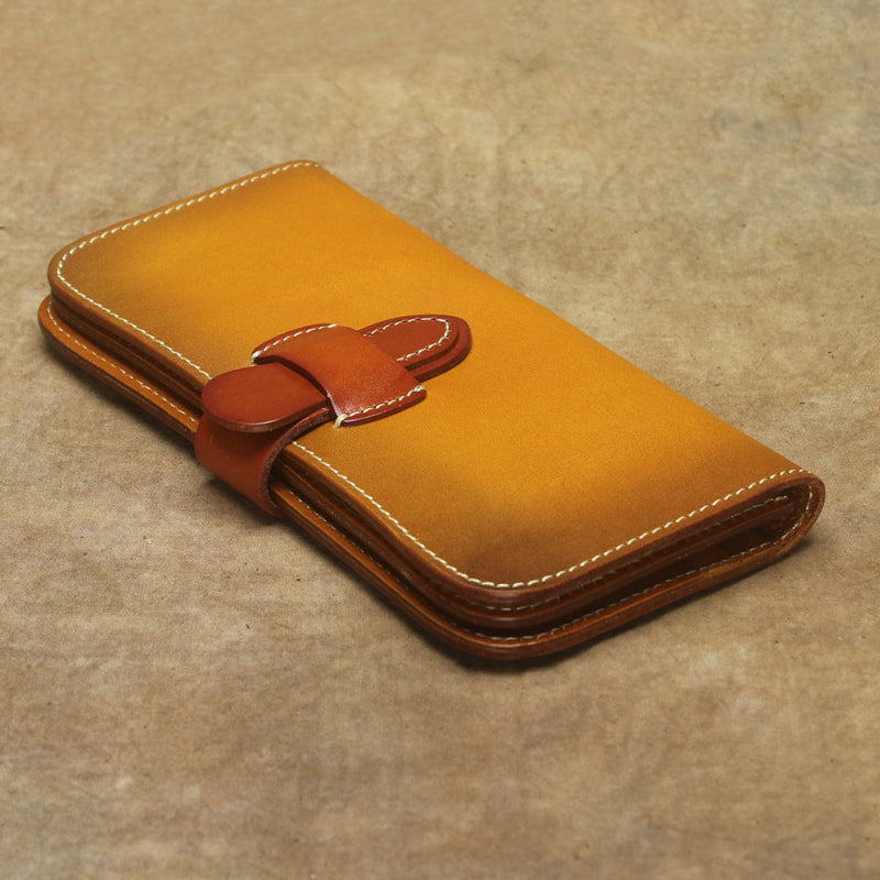 Full Grain Leather Long Wallet Hand Stitched Strap Clasp Clutch in vibrant yellow-brown color on textured background.