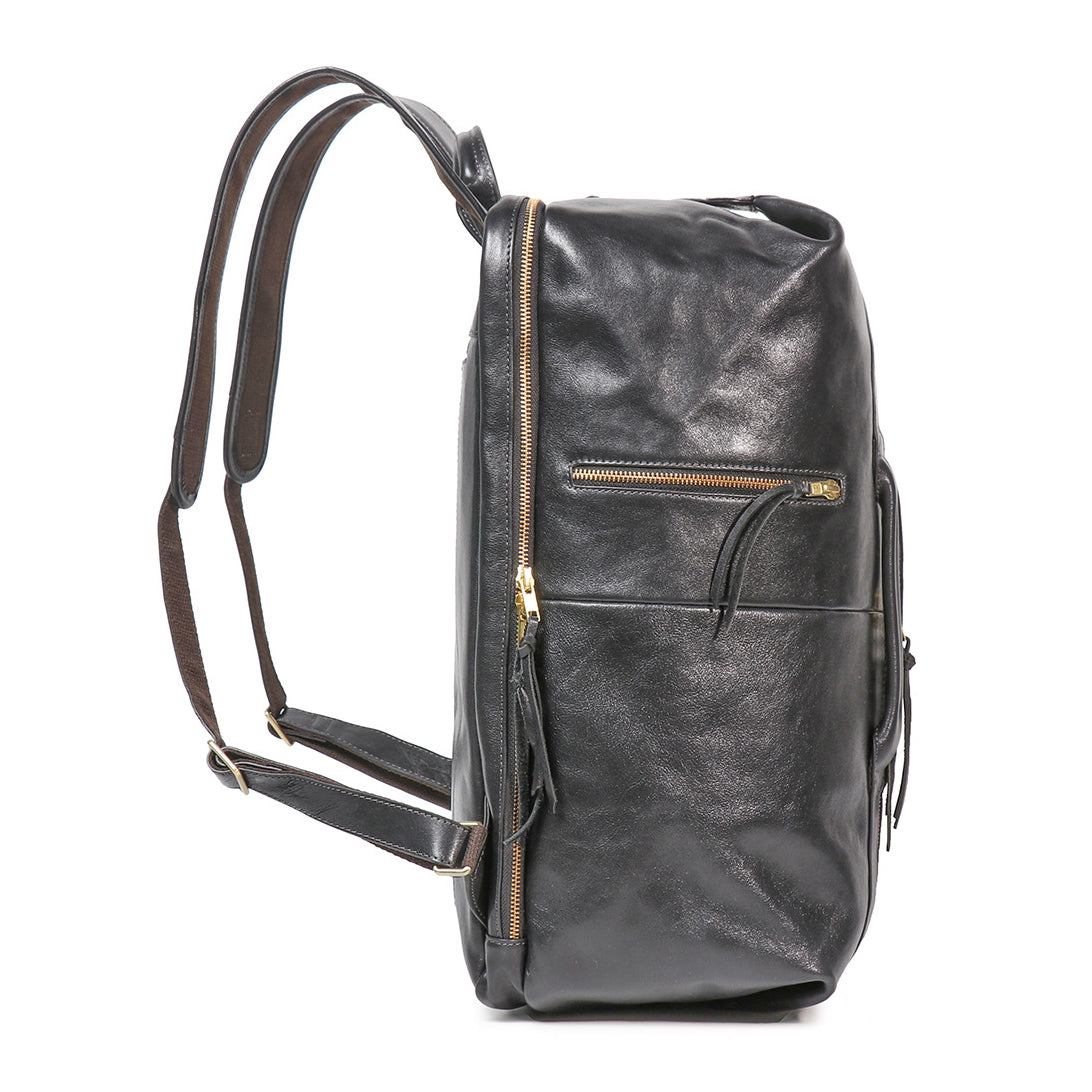 Side profile of an 18-inch executive black full-grain leather laptop backpack with gold zippers and padded straps.