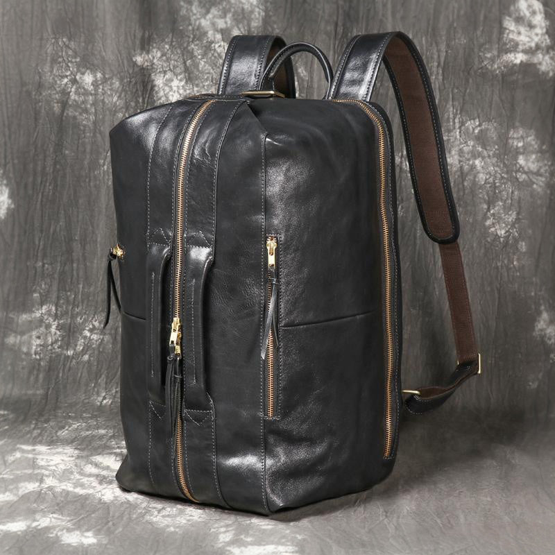 Executive 18-inch black full-grain leather laptop backpack with gold hardware and padded travel straps.