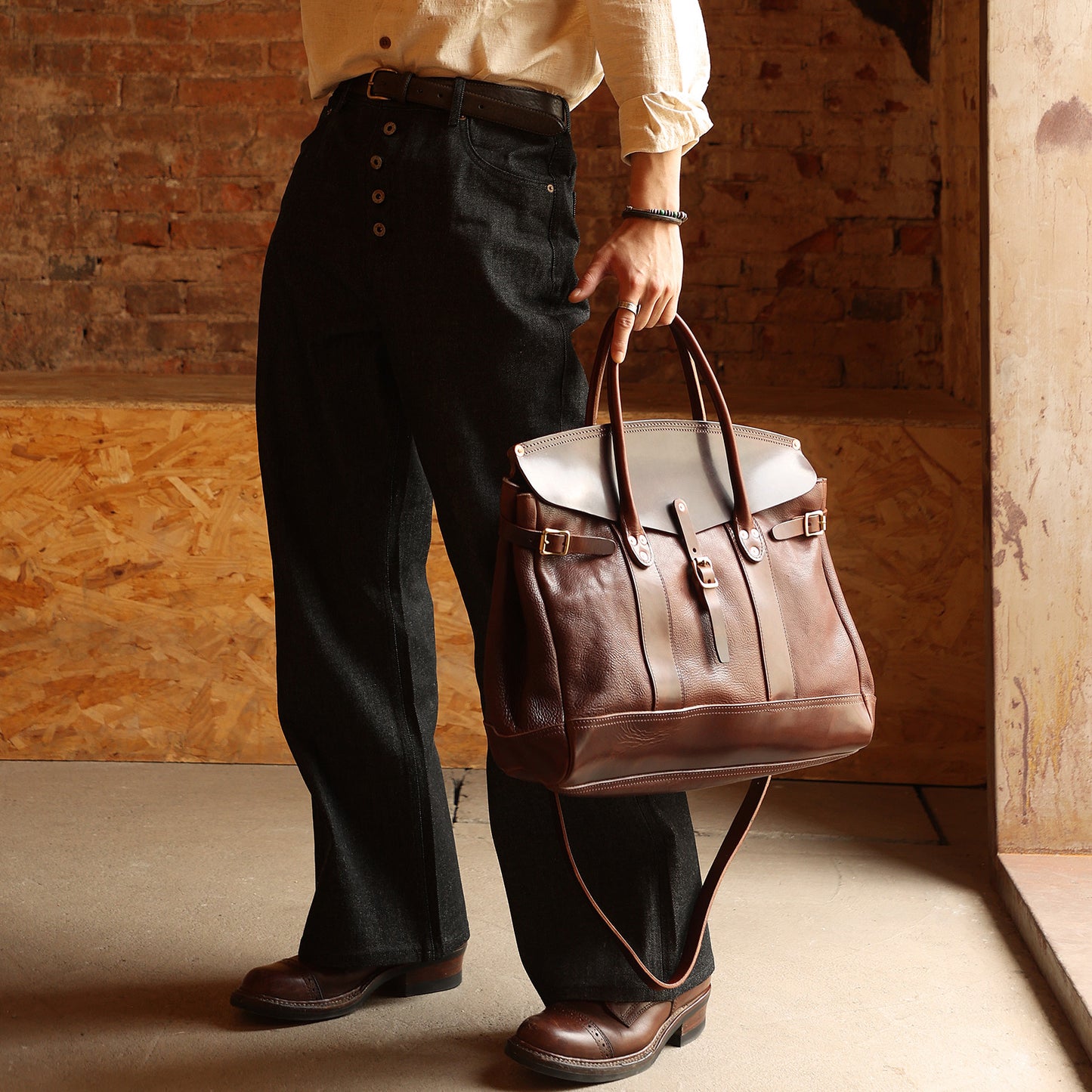 Person holding an Italian Leather Travel Bag, 17.7in large laptop tote with a stylish, classic design.