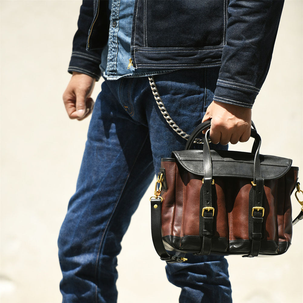 Man holding Italian Leather Messenger Bag 15.4in Cambridge Style Work Bag in dark brown and black.