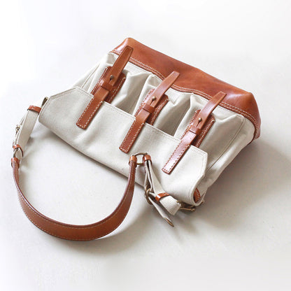 Canvas Leather Messenger Bag featuring three front pockets and a sleek design with a brown leather strap.