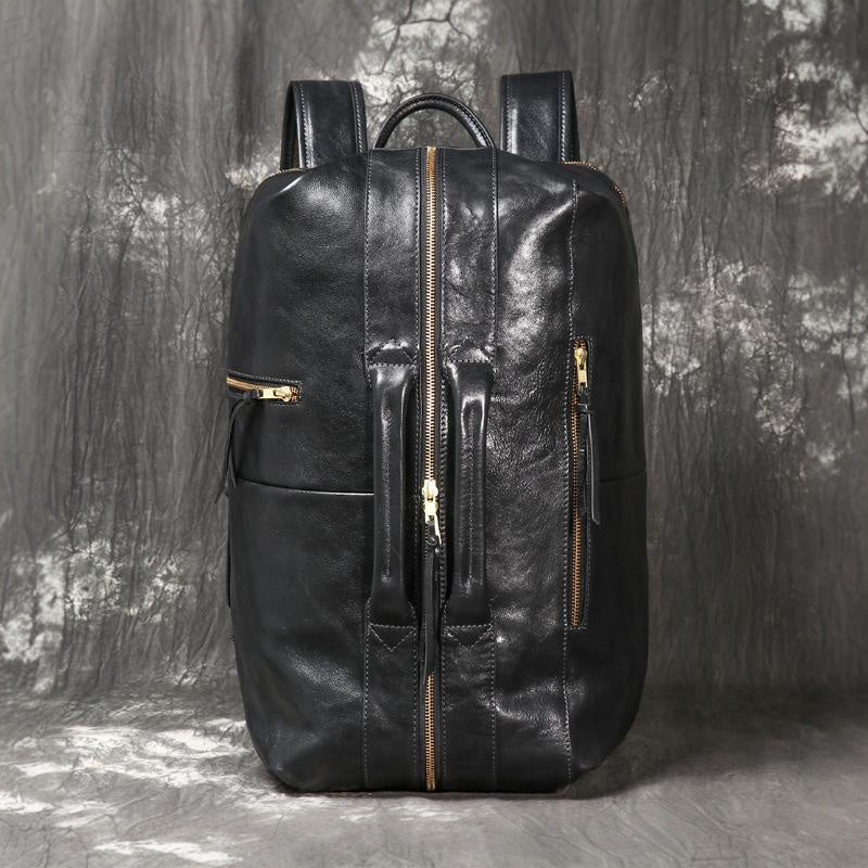 Executive 18-inch full-grain black leather laptop backpack with gold hardware and dual front carry handles.