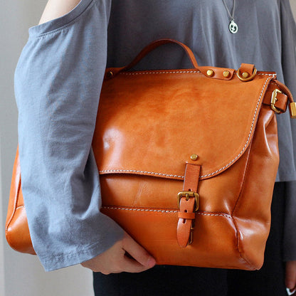 Leather Messenger Bag 13.8in Laptop Briefcase Crossbody Unisex being held in orange color.