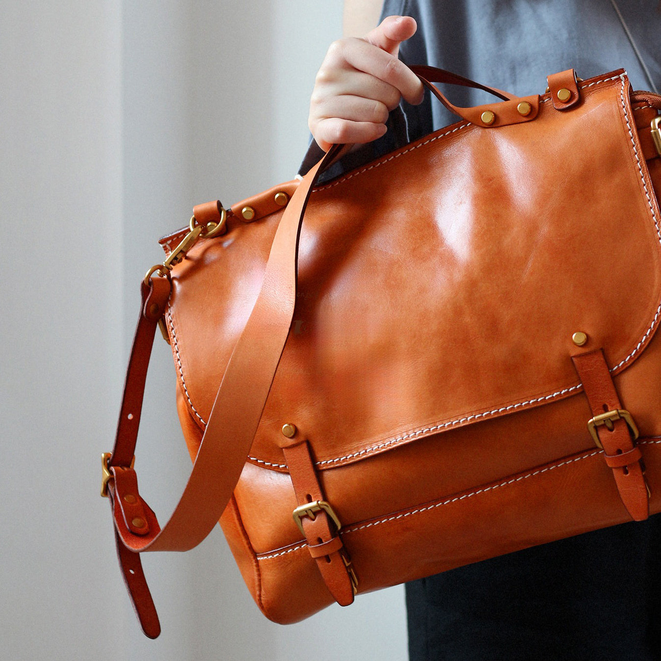 Leather Messenger Bag 13.8in Laptop Briefcase Crossbody Unisex being held by a person.