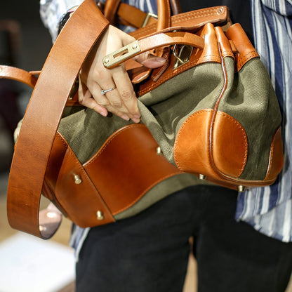 Leather Canvas Crossbody Bag held by a person, showcasing its stylish design and combination of leather and canvas materials.