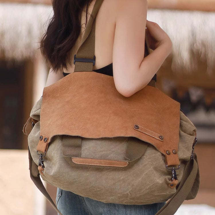 Woman carrying a soft leather canvas weekend bag in natural tones, showcasing the distressed top-grain leather and large tote design.
