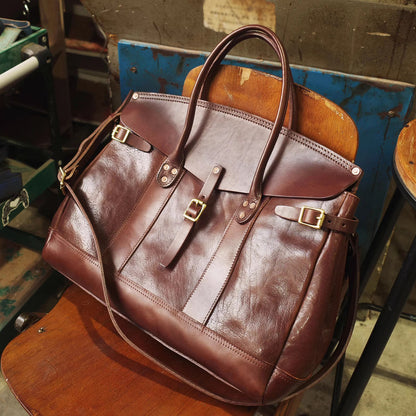 Italian Leather Travel Bag 17.7in Large Laptop Tote Weekender Briefcase on a wooden chair.
